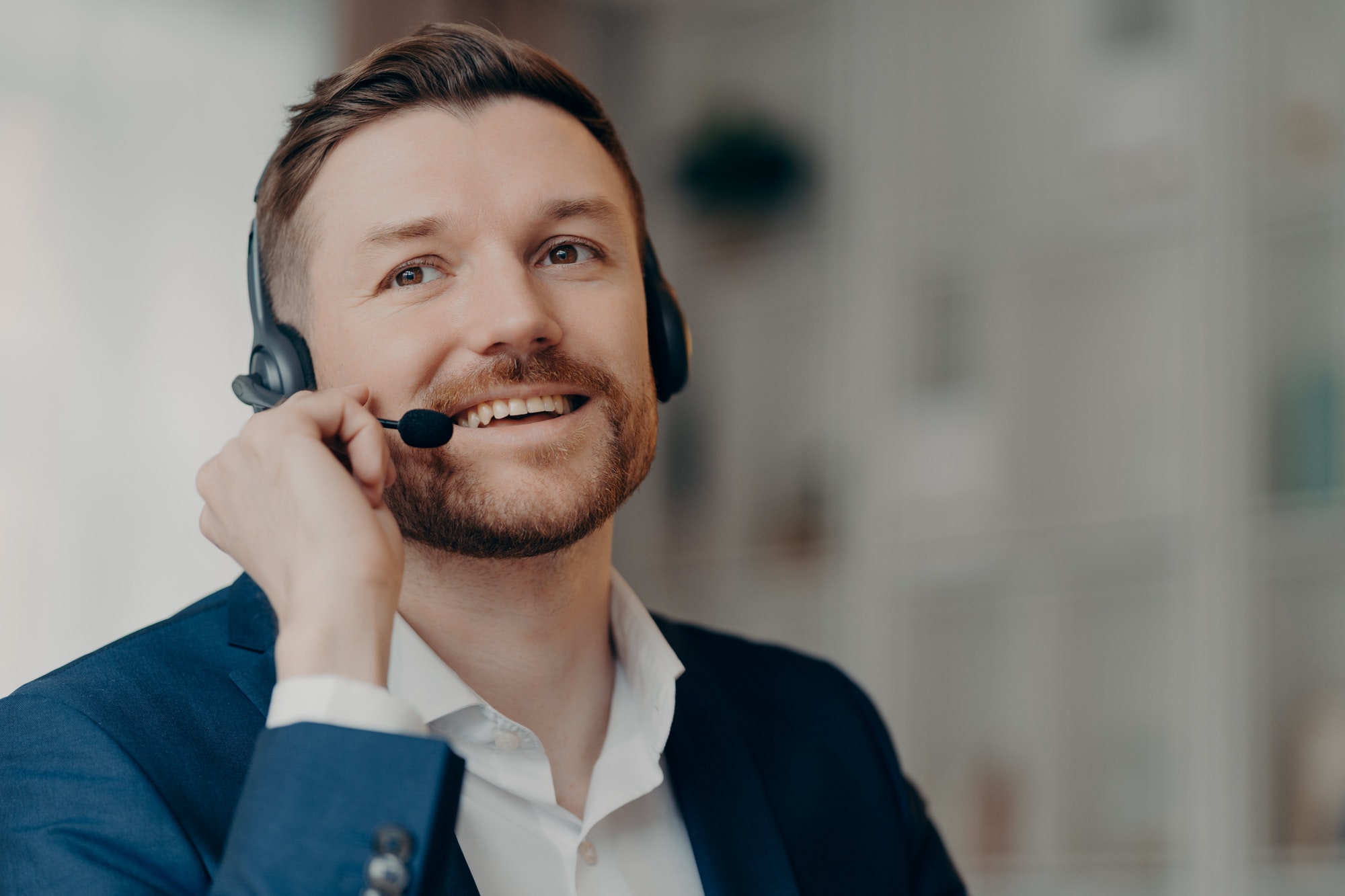 Happy young man consulting client by call