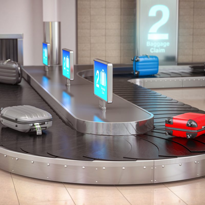 Suitcases on the airport luggage conveyor belt. Baggage claim. A
