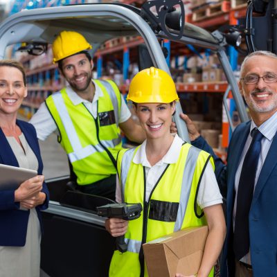 Warehouse manager and client standing with co-workers